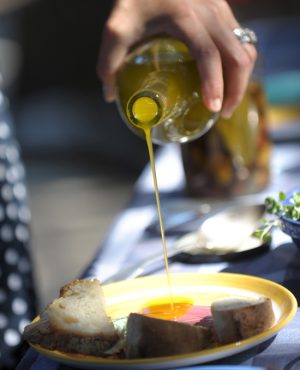 оливковое масло льют из бутылки на блюдо