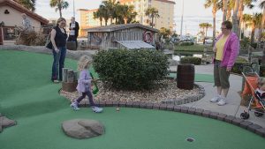 взрослые и дети играют в гольф