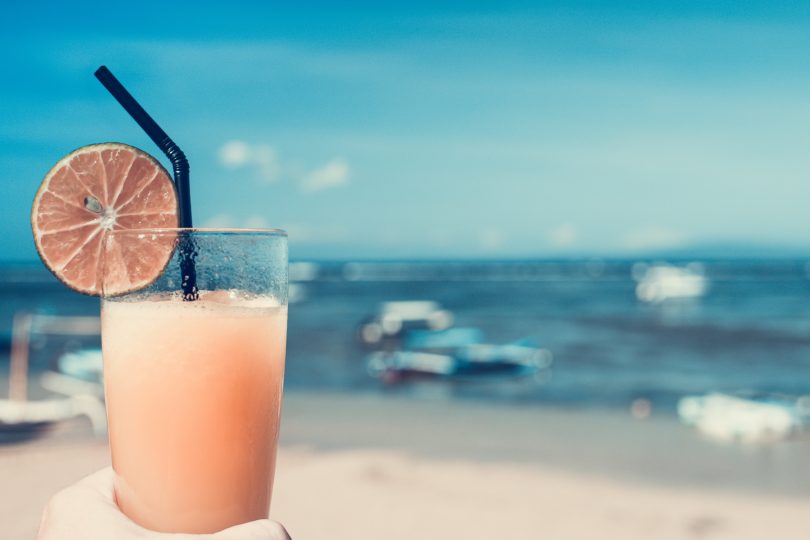 стакан с напитком на фоне моря