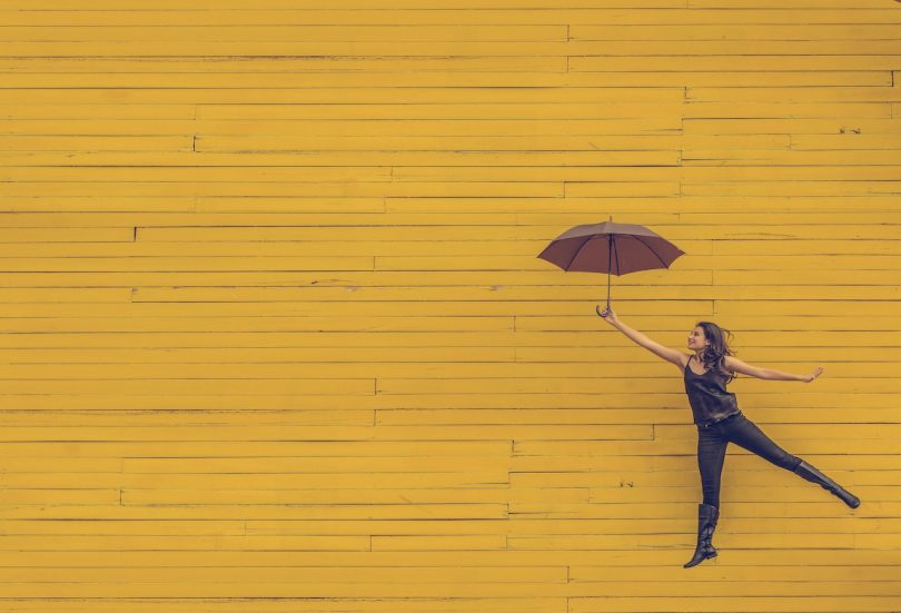 женщина с зонтиком на жёлтом фоне