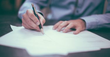 человек подписывает бумаги