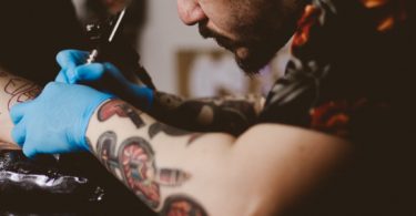 мужчина делает татуировку