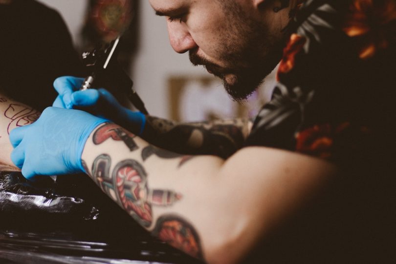 мужчина делает татуировку