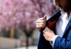 мужчина в синем костюме кладет кошелек во внутренний карман