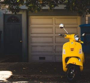 желтый мопед на фоне гаража и двери