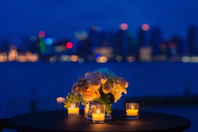 букет цветов и свечи на столе с видом на город