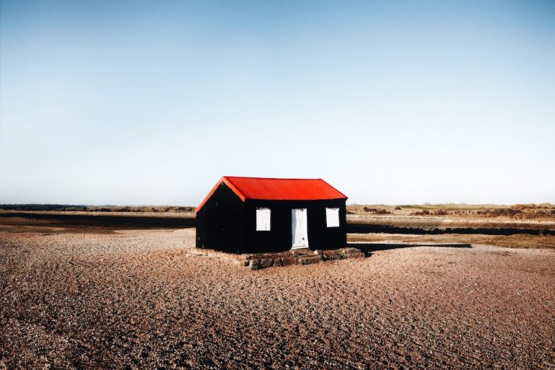 черный дом с красной крышей в пустыне