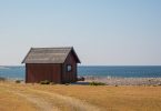 небольшой деревянный дом стоит у моря