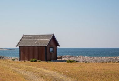 небольшой деревянный дом стоит у моря