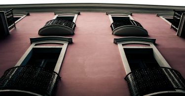 розовый фасад здания с балконами